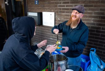 HAN-conciërge Arjan Bresser helpt de vrijwilligers bij het opscheppen (Stichting Straatmensen in Nijmegen)